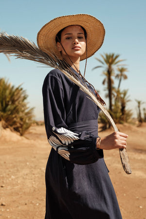 Woman wearing Kleed Blue Kandy Kimono in 100% cotton dark navy blue white floral embroidered cuffs outdoor desert editorial