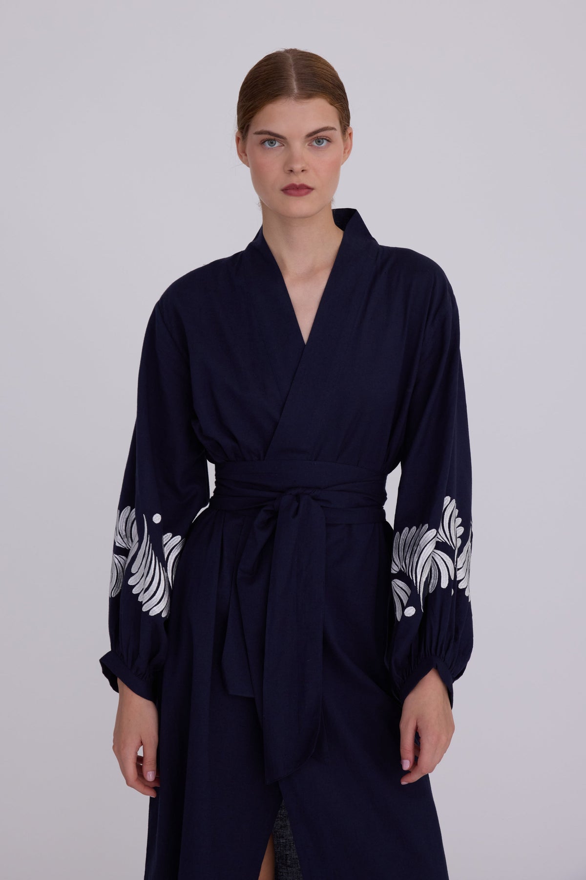 Woman wearing Kleed Blue Kandy Kimono in 100% cotton dark navy blue white floral embroidered cuffs front view studio