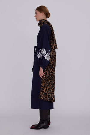 Woman wearing Kleed Blue Kandy Kimono in 100% cotton dark navy blue white floral embroidered cuffs side view styled with leopard print scarf and cowboy boots