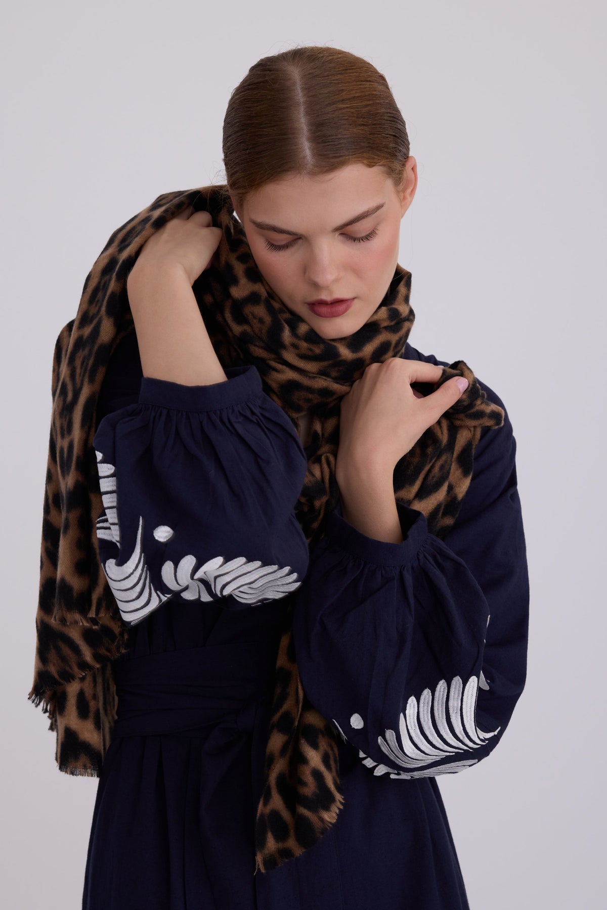 Woman wearing Kleed Blue Kandy Kimono in 100% cotton dark navy blue white floral embroidered balloon sleeve cuffs styled with leopard print scarf