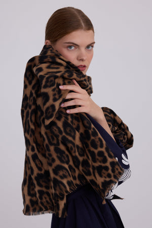 Woman wearing Kleed Blue Kandy Kimono in 100% cotton dark navy blue with white floral embroidered cuffs wrapped in leopard print scarf studio