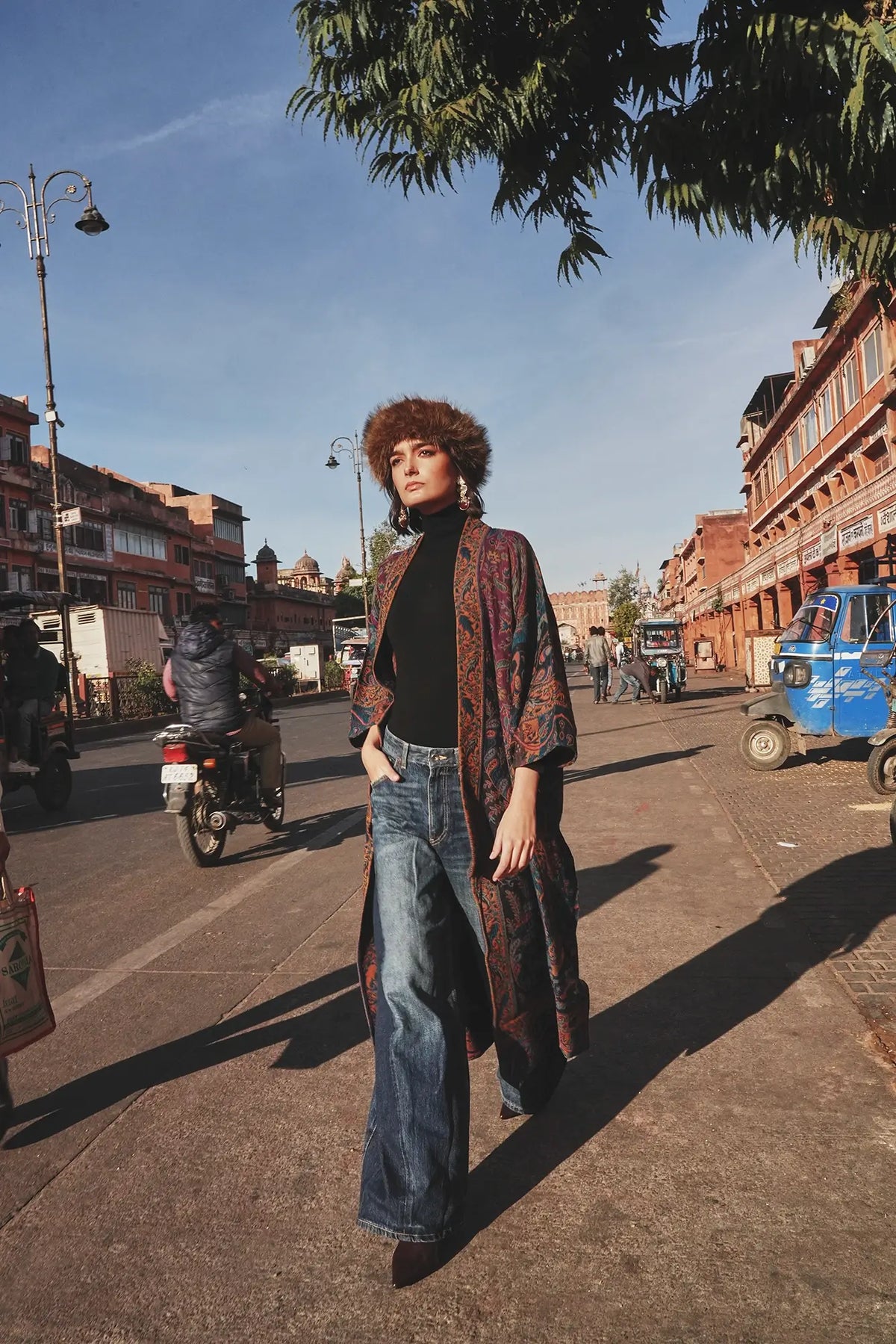 Kleed Fuchsia Paisley Kimono Coat in wool styled with a wide-brim hat and jeans for an urban look.
