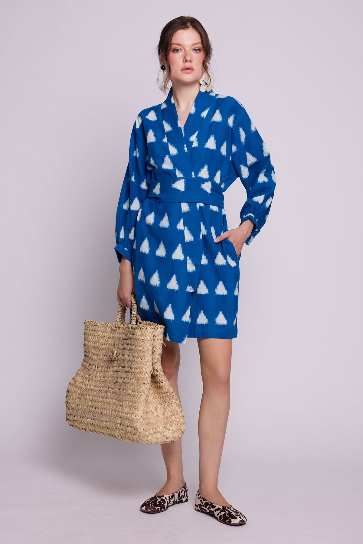 Back view of model wearing Kleed Turquoise Savannah Short Kimono in handwoven Ikat cotton, tied at the waist with matching belt.