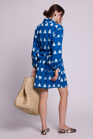 Model wearing Kleed Turquoise Savannah Short Kimono in handwoven Ikat cotton with balloon sleeves and matching belt, with a straw tote.