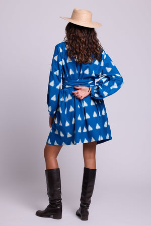 Model standing wearing Kleed Turquoise Savannah Short Kimono in Ikat cotton, styled with a straw hat and black knee-high boots.