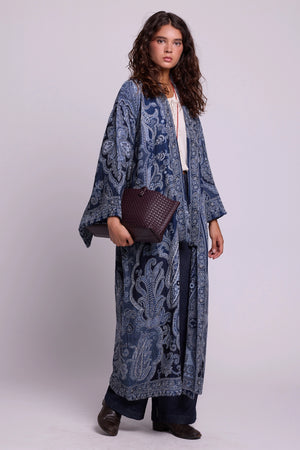 Full length view of Kleed Blue Paisley Kimono Coat in pure wool with paisley print, worn with jeans on the street.
