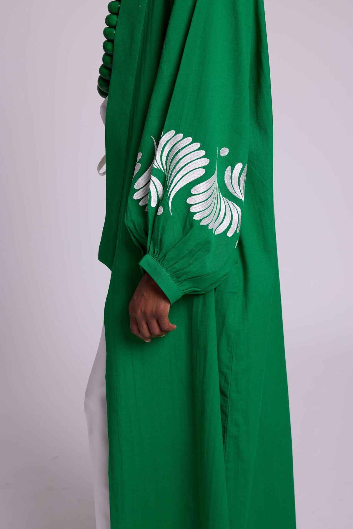 Close up detail of the Kleed Emerald Green Kandy Kimono sleeve showing intricate white floral sleeve embroidery on vibrant green 100% cotton
