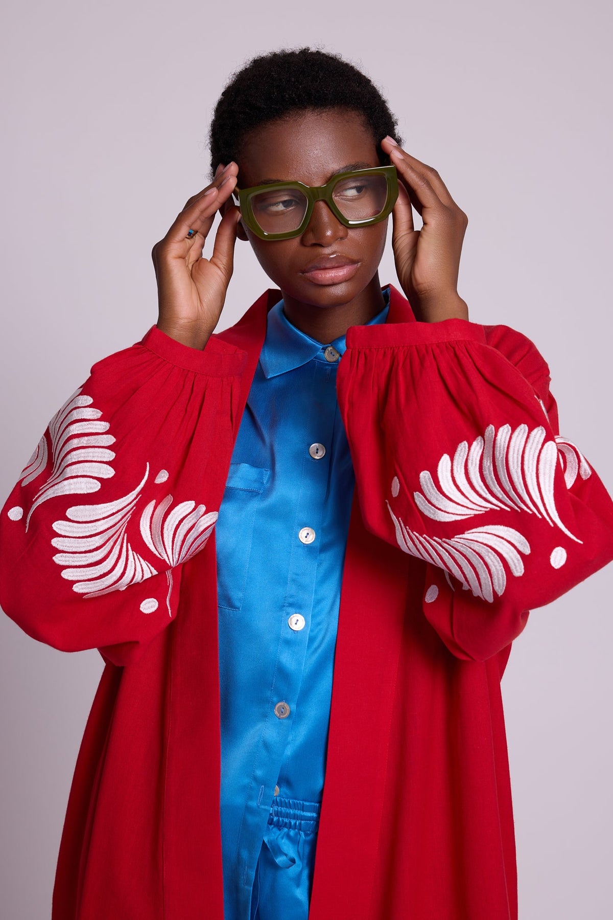 Woman wearing Kleed Red Kandy Kimono in cotton with balloon sleeves and white silk embroidered cuffs.

