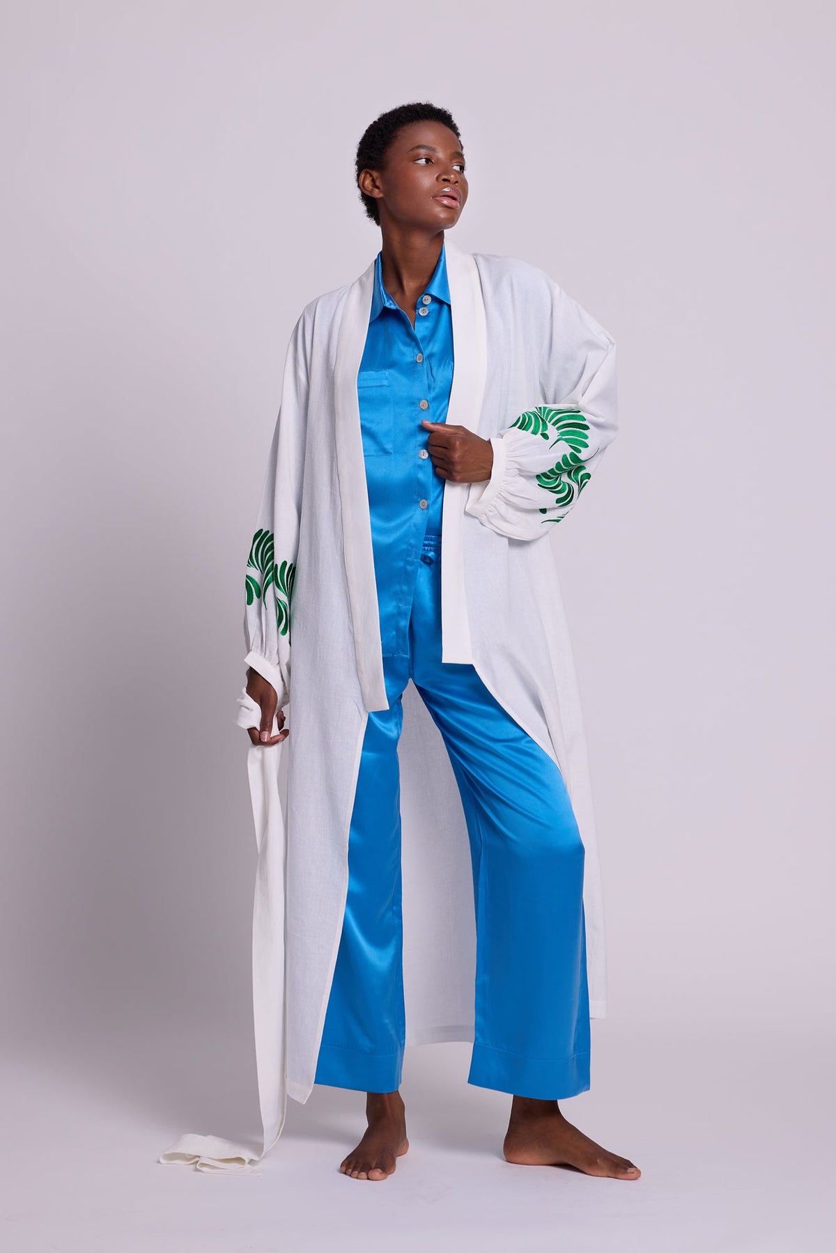 Full length view of Kleed Light Kandy Kimono in white cotton, styled over a sky blue silk pyjama set.
