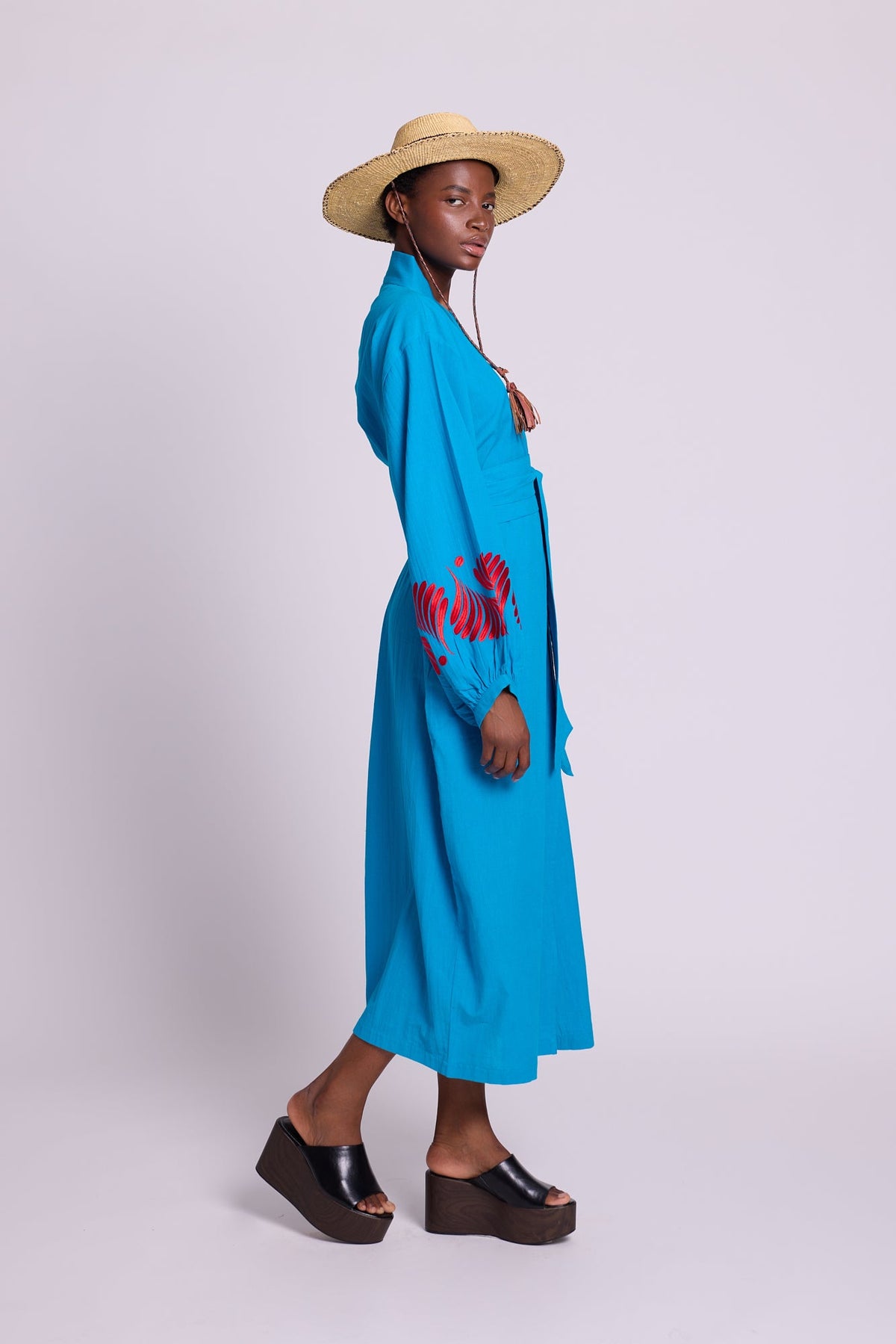 Kleed Sky Blue Kandy Kimono in cotton with balloon sleeves and red embroidered cuffs, worn with a straw hat.
