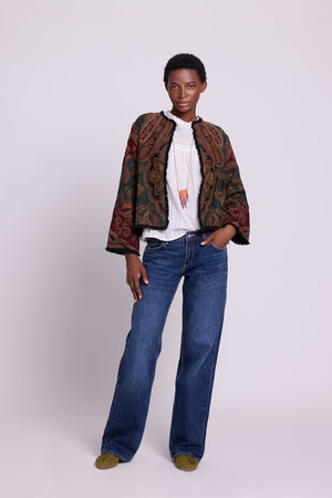 Full length view of Kleed Green Oak Jacket in wool with paisley print, styled with white top and wide-leg jeans.
