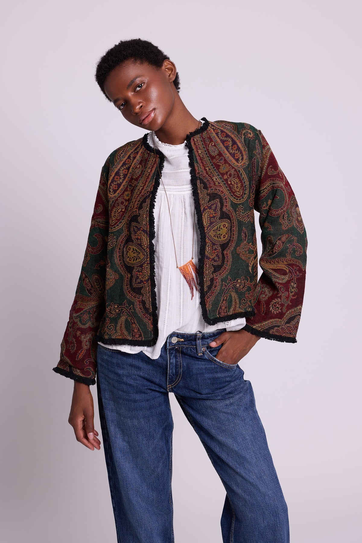 Kleed Green Oak Jacket in wool with paisley swirls and cropped silhouette, styled with white top and jeans.