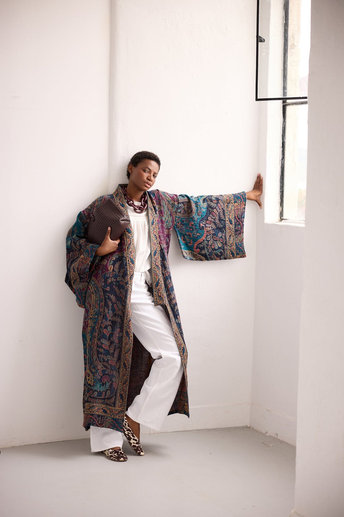 Kleed Fuchsia Paisley Kimono Coat in 100% wool, full length view in natural light, styled with white trousers.