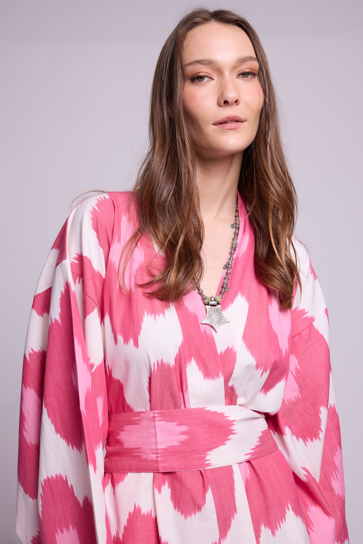 Close-up of Hira Pink Kimono by KLEED — handloomed ikat cotton fabric detail in pink and white with wrap neckline