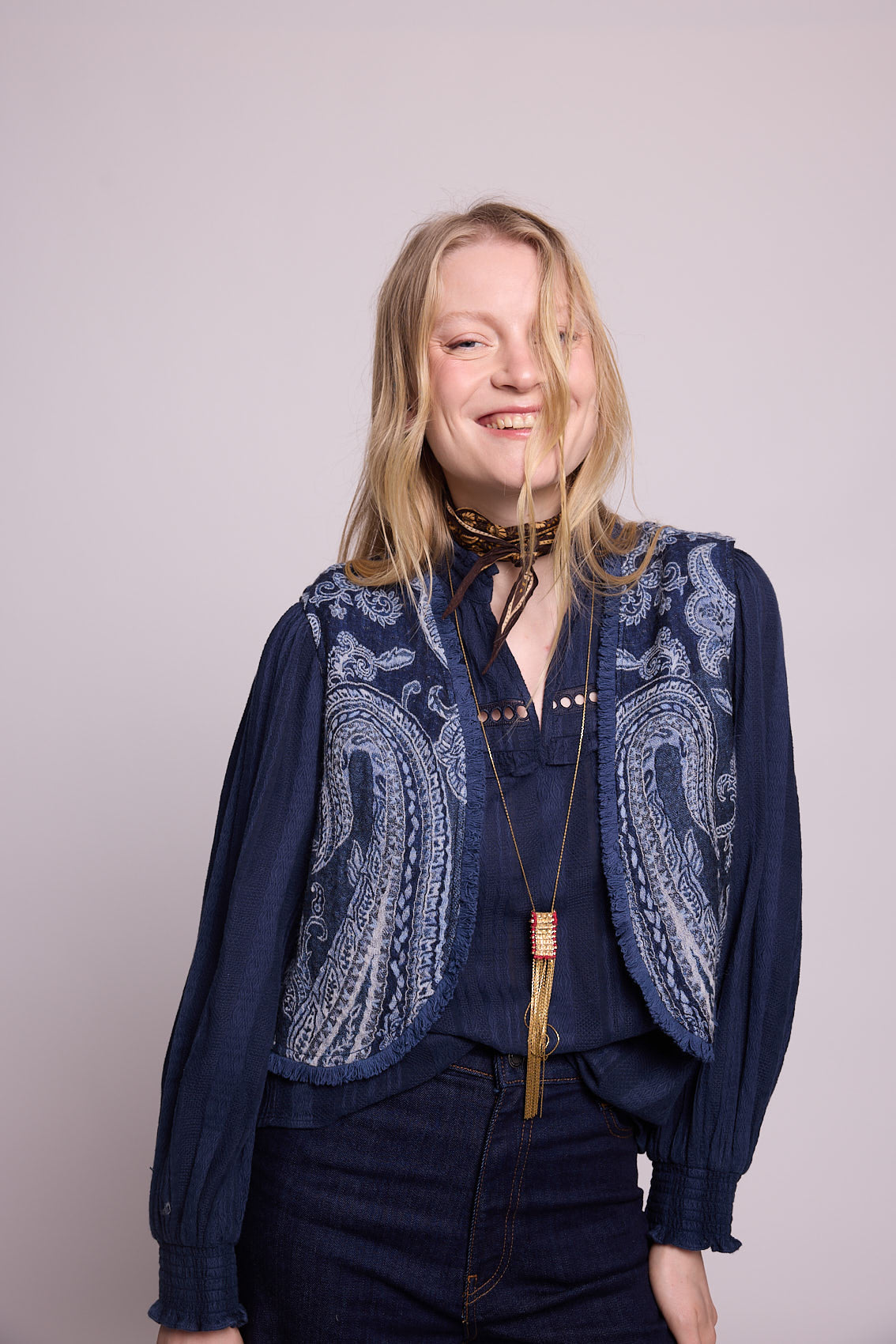 Side profile view of woman wearing the Kleed Blue Paisley Vest in navy wool