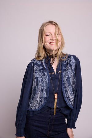 Side profile view of woman wearing the Kleed Blue Paisley Vest in navy wool