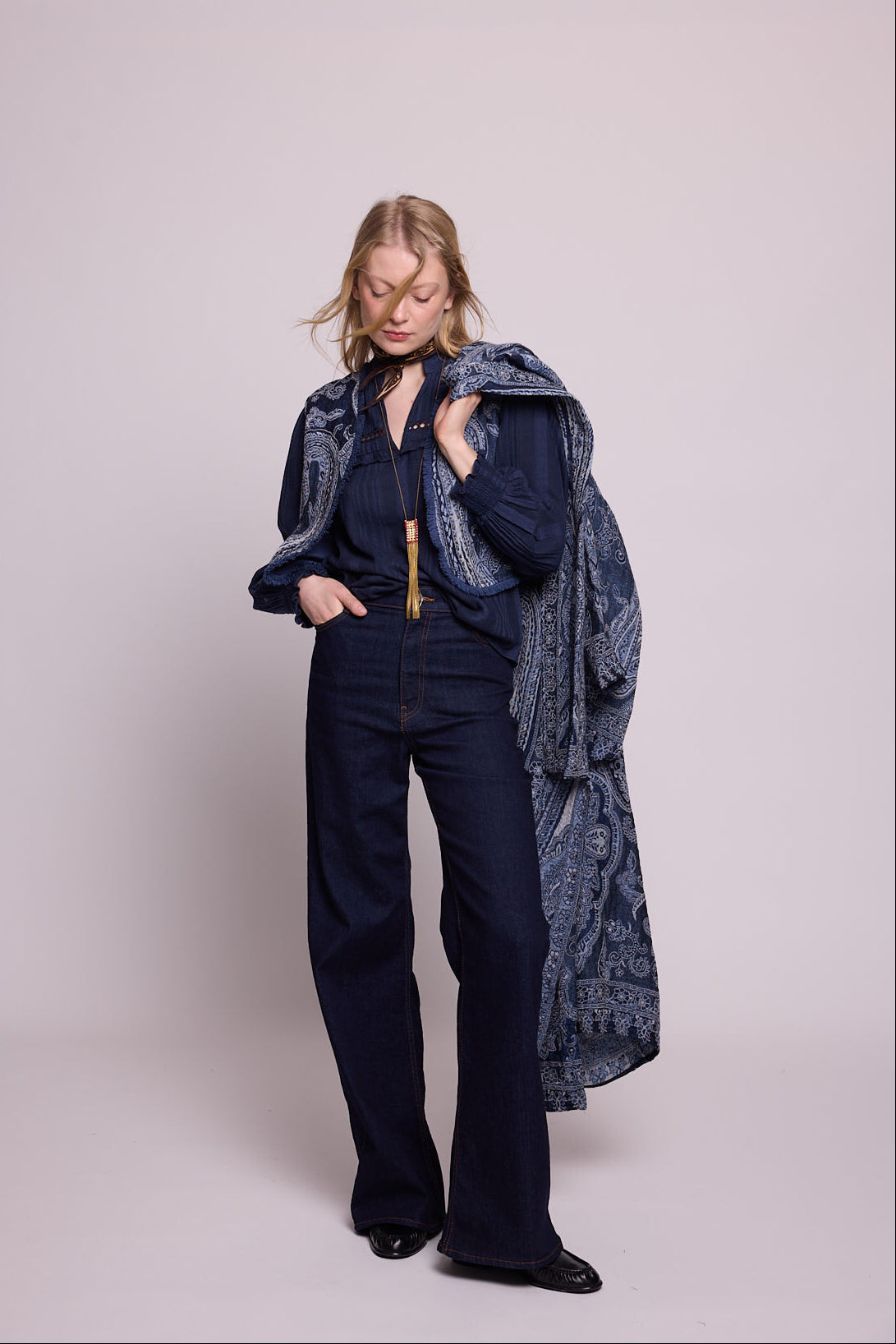 Full length alternative pose of woman wearing the Kleed Blue Paisley Vest in navy wool with wide leg trousers