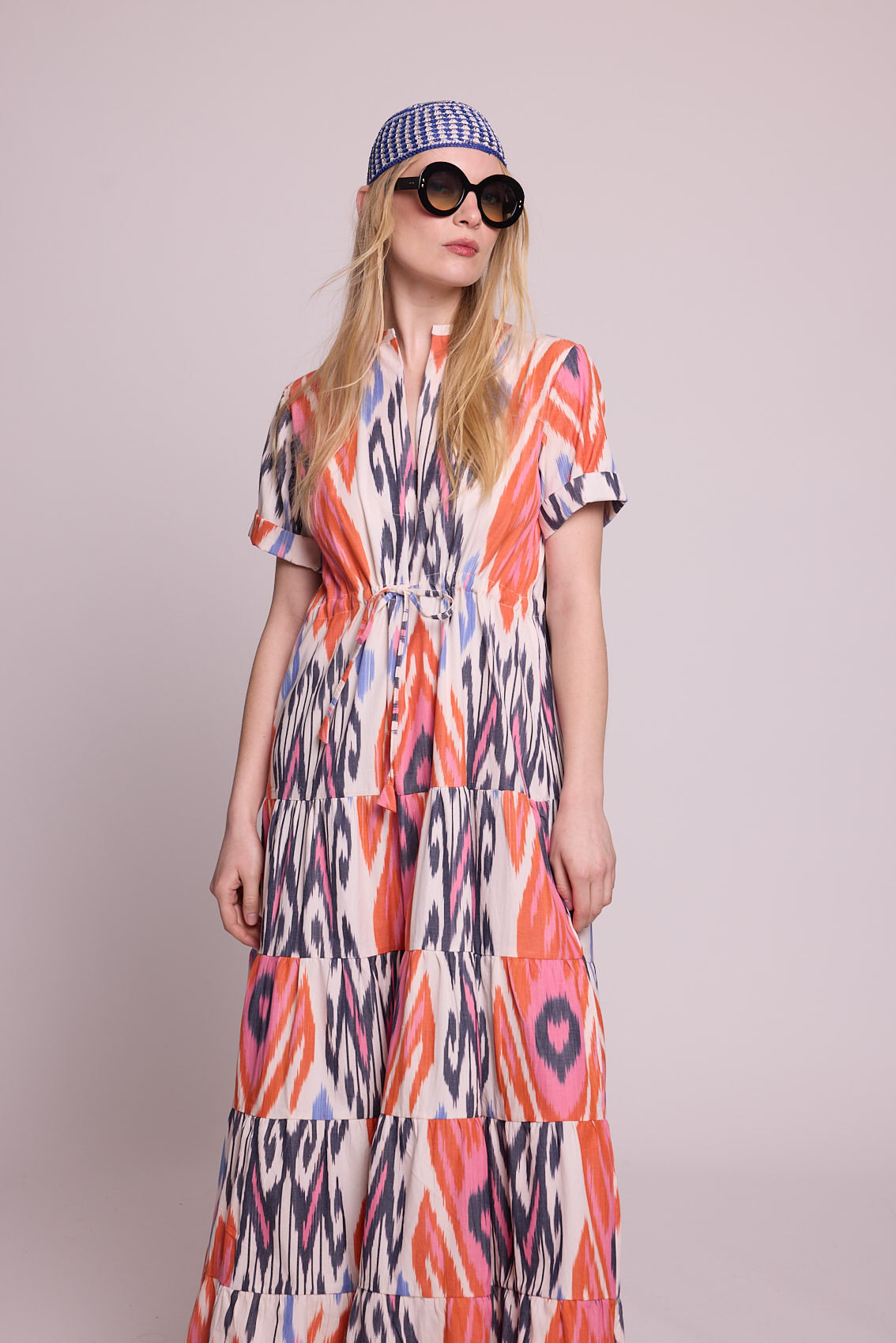 Full length front view of a woman wearing the Kleed Tangerine Bikaner Maxi Dress in handloomed cotton ikat, plain background