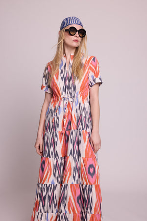 Full length front view of a woman wearing the Kleed Tangerine Bikaner Maxi Dress in handloomed cotton ikat, plain background