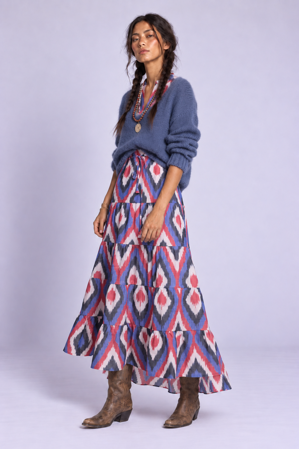Model wearing the Bahu Bikaner Dress by KLEED, a slow fashion maxi dress in handloomed cotton ikat, styled for fall with blue knitwear and cowboy boots.