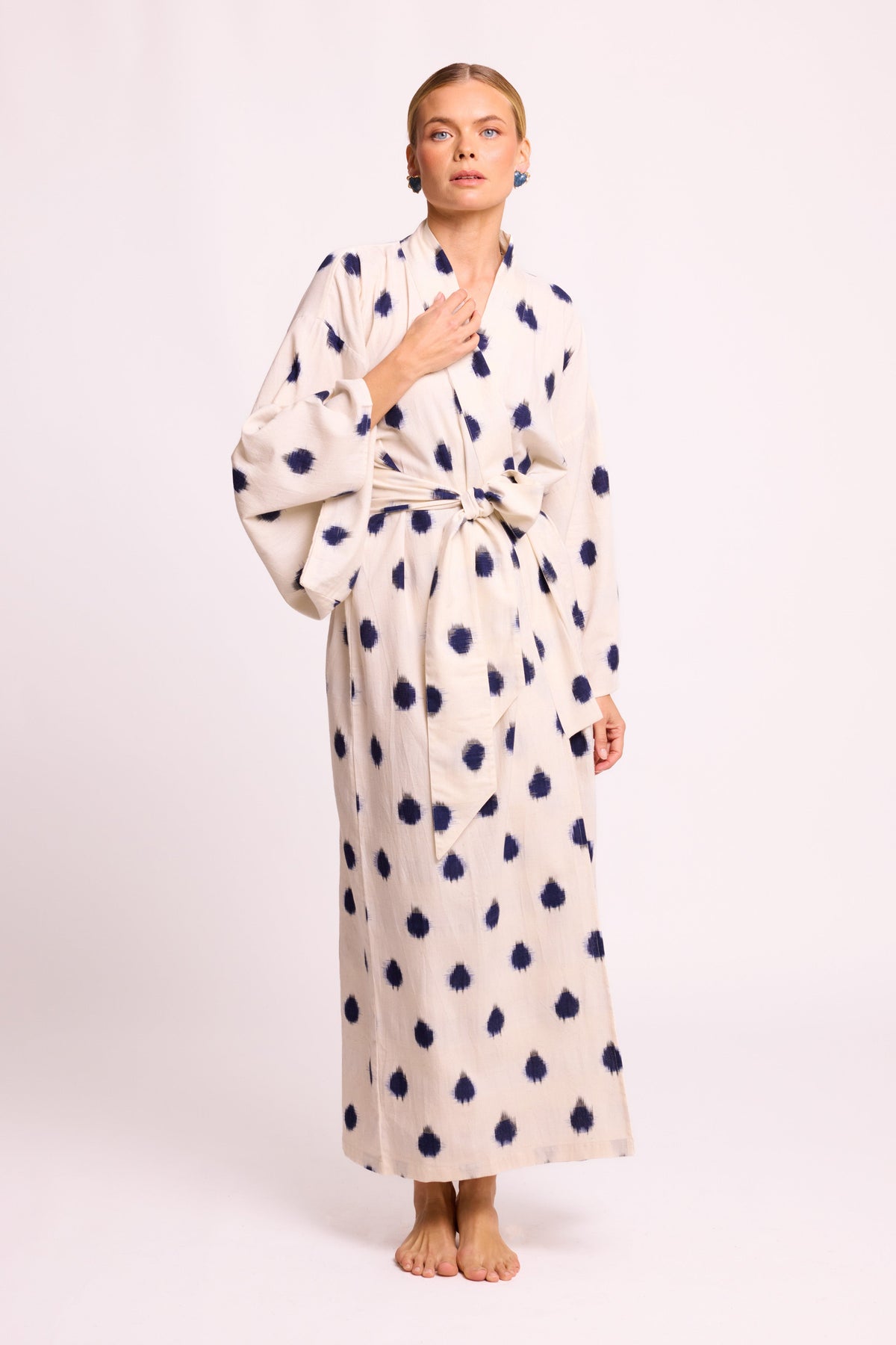 Woman wearing Kleed Blue Dots Bee Kimono in 100% handwoven Ikat cotton cream with navy polka dot pattern front view studio