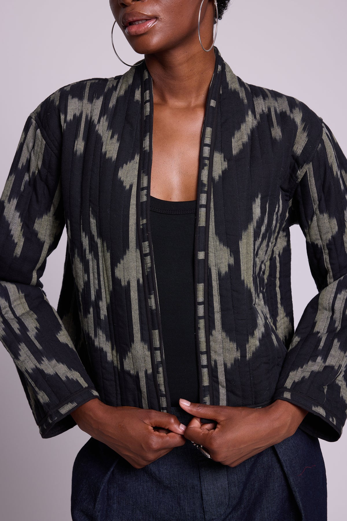 Lookbook photo of model wearing the Kleed Congo jacket, close-up of the quilted hand-loomed ikat cotton in black and khaki