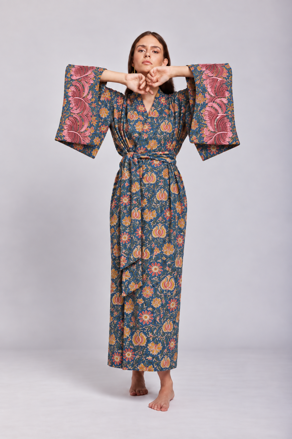 Model wearing the Gulab Kimono by KLEED, a 100% cotton hand block printed women’s kimono with a blue floral pattern, pink embroidered cuffs and matching belt.