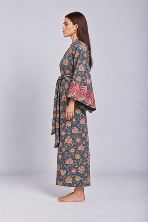 Side view of model wearing the Gulab Kimono by KLEED, a luxury cotton kimono with hand block printed floral design, wide sleeves and pink embroidered cuffs.
