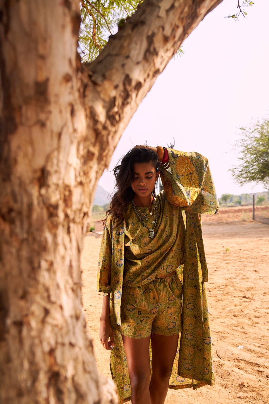 front view of the Kleed Jasmine Kimono, an oversized handcrafted cotton kimono in olive and yellow, photographed in country side landscape