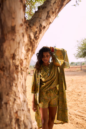 front view of the Kleed Jasmine Kimono, an oversized handcrafted cotton kimono in olive and yellow, photographed in country side landscape