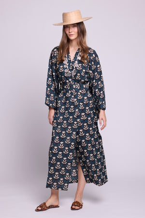 front side lookbook image of model wearing kleed's krisant naya kimono in 100% hand blockprinted cotton. Wearinga straw hat and caramel animal print flat sandals.
