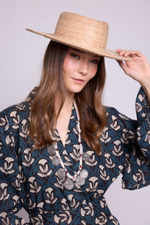 model holding a straw hat, weraing kleed's krisant naya kimono. 100% hand block printed. Artisanal and quiet loungewear.