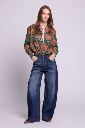 KLEED Lotus Green Shirt, women’s cotton shirt in 100% hand block printed cotton with a rich green floral print, mother-of-pearl buttons and relaxed fit, styled with wide-leg denim in a clean studio fashion photo.