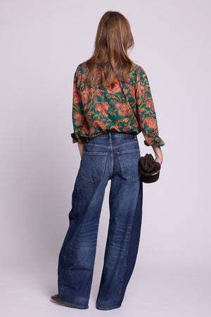 KLEED Lotus Green Shirt, back view of a women’s cotton shirt in 100% hand block printed cotton with a rich green floral print and relaxed fit, styled with wide-leg denim and a textured dark bag in a clean studio fashion photo.