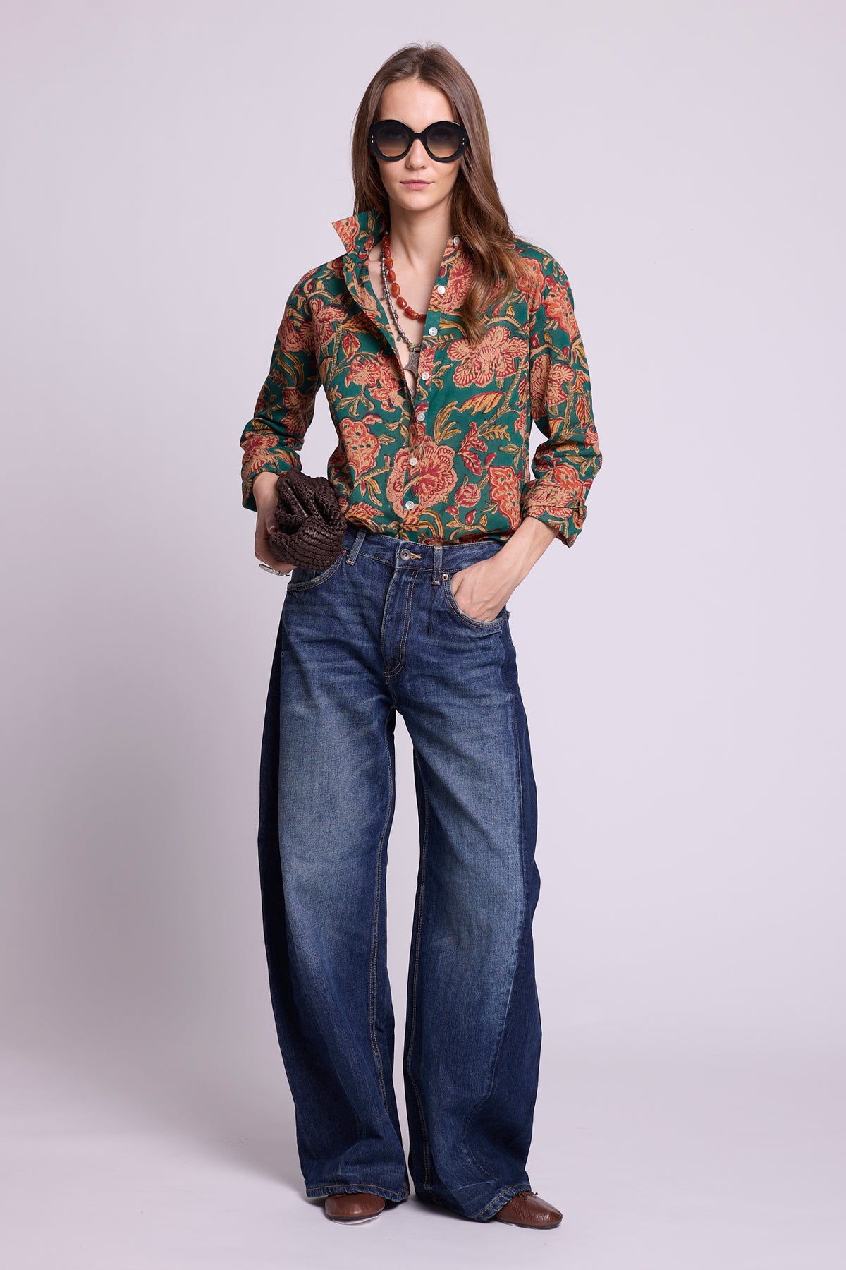 KLEED Lotus Green Shirt, women’s cotton shirt in 100% hand block printed cotton with a rich green floral print, mother-of-pearl buttons and relaxed fit, styled with wide-leg jeans and oversized sunglasses as handcrafted resortwear.