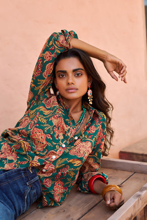 Woman wearing Kleed Green Lotus Shirt, a hand block printed 100% cotton shirt with green and coral floral print, styled with denim jeans