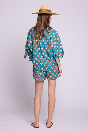 :Back view of Mogra Turquoise Pyjama by KLEED — hand block printed 100% cotton shirt and shorts in teal with coral floral printBack view of Mogra Turquoise Pyjama by KLEED — hand block printed 100% cotton shirt and shorts in teal with coral floral print