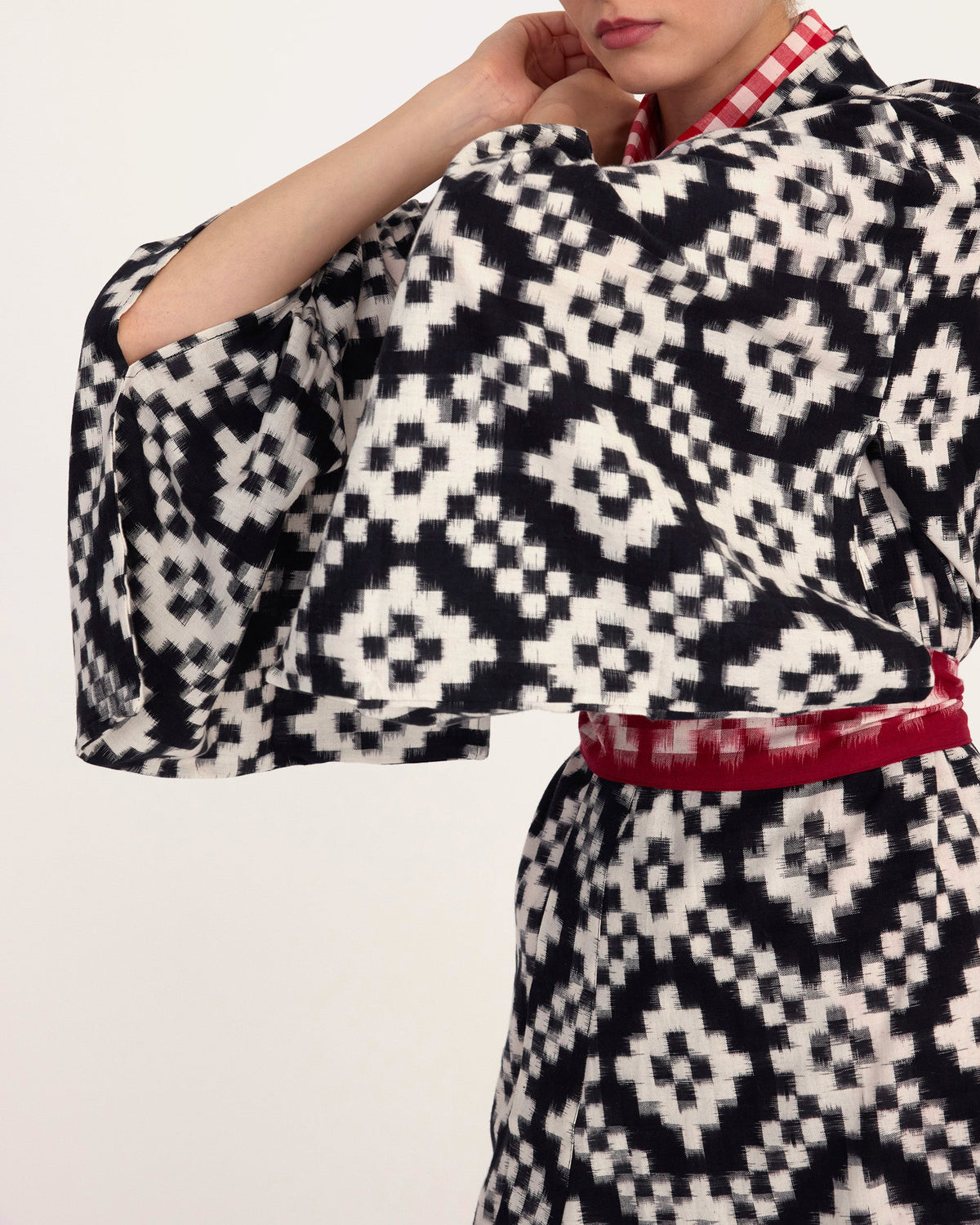 model wearing a black and white patterned kimono by kleed with a red belt on a light background