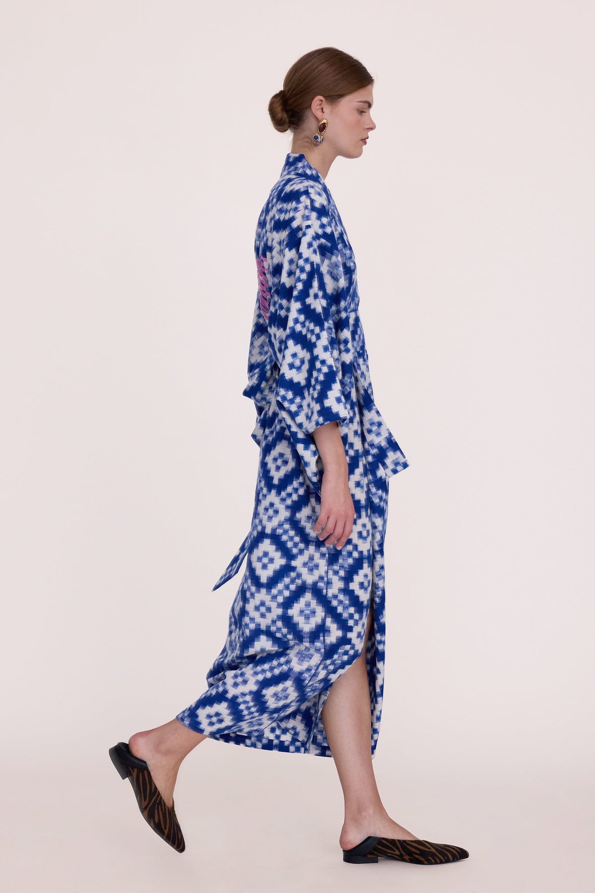 Woman wearing Kleed Mombasa Blue Kimono in handwoven Ikat cotton blue and white geometric pattern side view studio