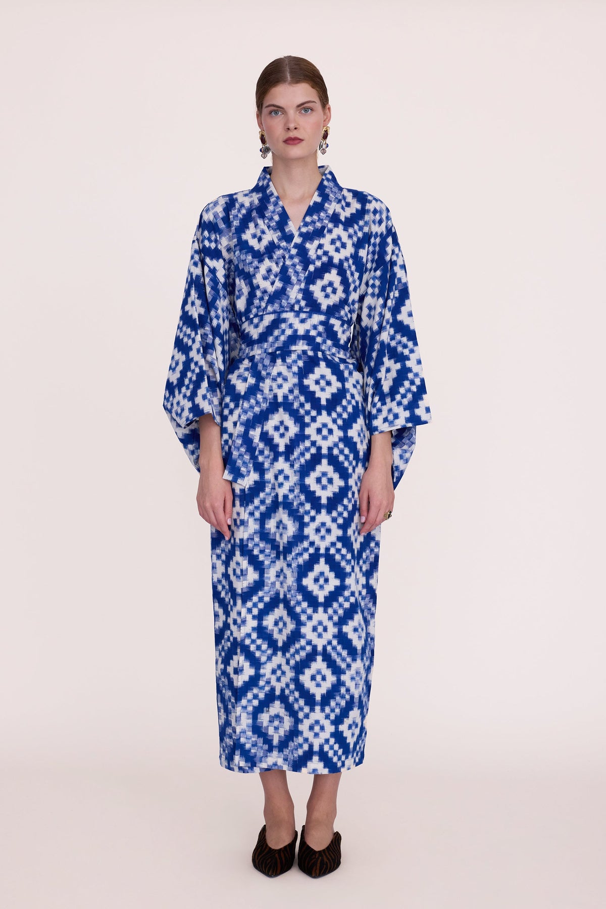 Woman wearing Kleed Mombasa Blue Kimono in handwoven Ikat cotton blue and white geometric pattern front view studio