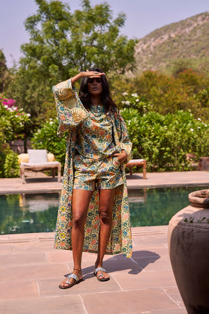 The Kleed Palash Kimono styled with a wide-brim hat as a poolside cover-up, handcrafted cotton kimono with hand block printed florals