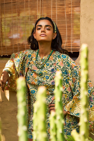 Editorial portrait of the Kleed Palash Kimono, conscious luxury handcrafted cotton kimono in cream with floral motifs.
