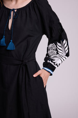 Close-up of the KLEED Portofino Black Kaftan showing the waist, sleeve embroidery and blue tassel detail.