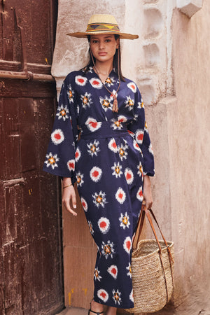 Woman wearing Kleed Sushi Kimono in handloomed Ikat cotton navy blue geometric pattern standing against ancient wall