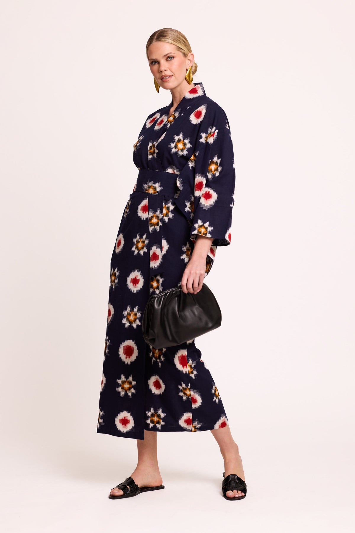 Woman wearing Kleed Sushi Kimono in handloomed Ikat cotton dark blue with geometric pattern in red yellow and white
