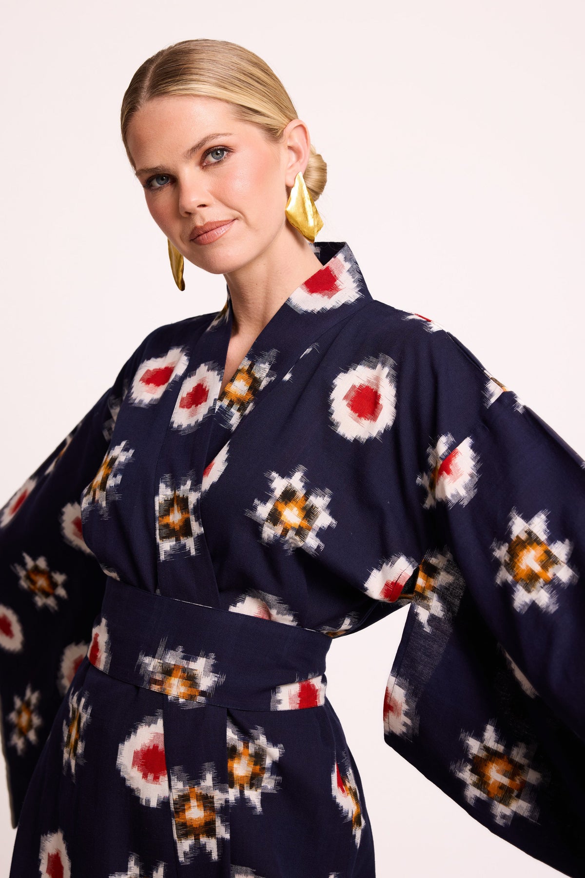 Close up of woman wearing Kleed Sushi Kimono in handloomed Ikat cotton navy blue geometric pattern in red yellow and white