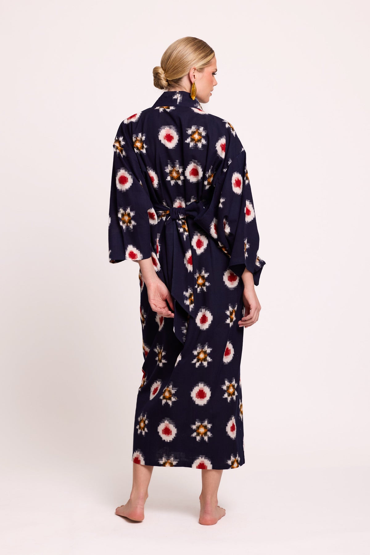 Back view of woman wearing Kleed Sushi Kimono in handloomed Ikat cotton navy blue geometric pattern in red yellow and white