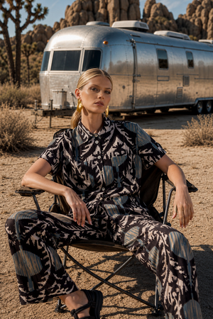 model wearing yala blue pyjama by kleed seated in a chair at the desert for an editorial shoot for Kleed. The pyjama is 100% cotton hand blockprinted.