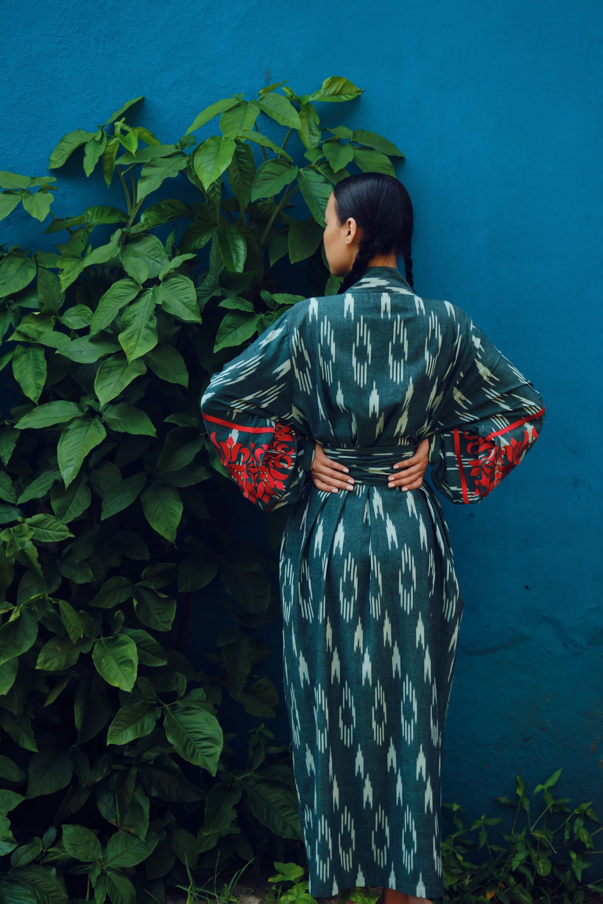 Kleed Zimbabwe Kandy Kimono: a green handloomed cotton kimono with natural geometric motifs and red silk embroidery